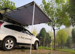 Szara markiza samochodowa Far Away Equipment Classic rozłożona przy aucie w lesie